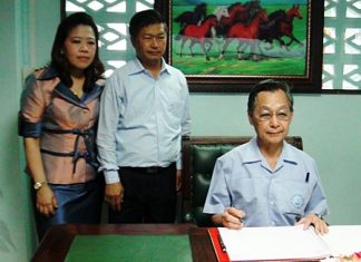 Former Prime Minister Chuan Leekpai signs the guestbook at the new Democrat Party headquarters in Chonburi.
